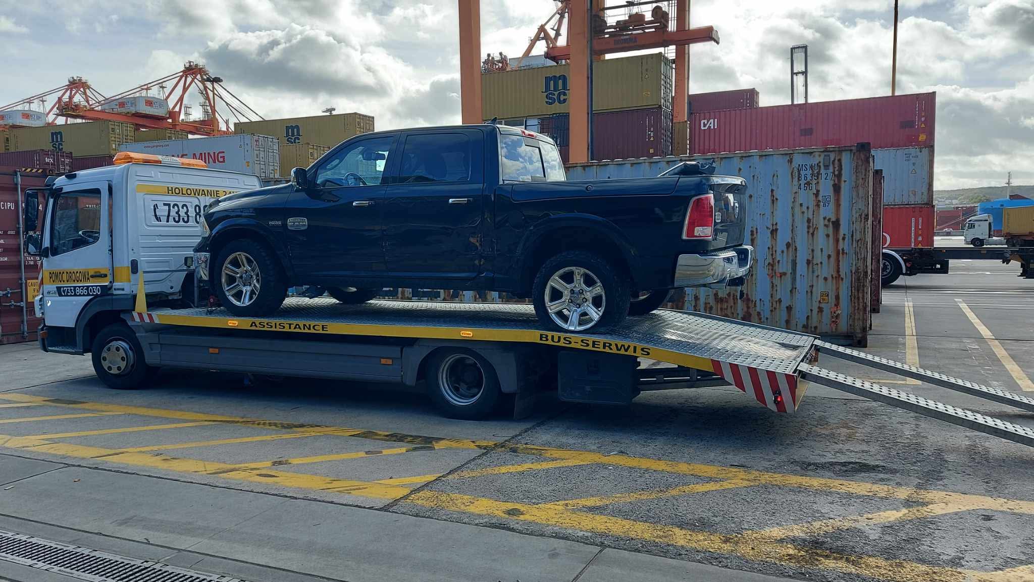Laweta firmy transportująca samochód na terenie portu